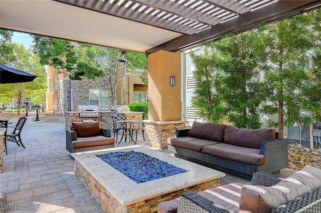 view of patio featuring a pergola, an outdoor kitchen, an outdoor living space with a fire pit, and area for grilling