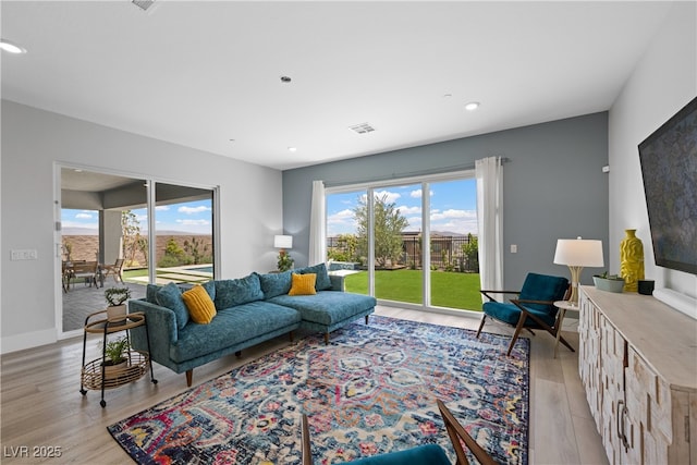 living room with light wood finished floors, baseboards, visible vents, and recessed lighting