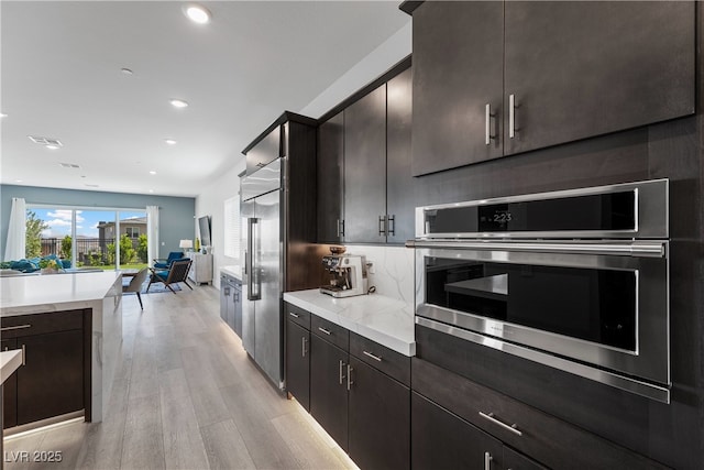 kitchen with light wood-style flooring, open floor plan, recessed lighting, and appliances with stainless steel finishes