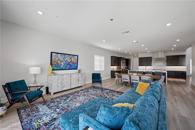 living area featuring baseboards, recessed lighting, light wood-style floors, and visible vents