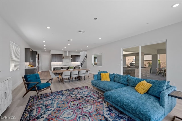 living area with light wood finished floors, baseboards, and recessed lighting