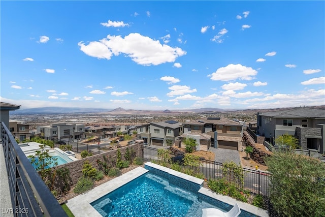 view of swimming pool with a residential view, a fenced in pool, a fenced backyard, and a mountain view