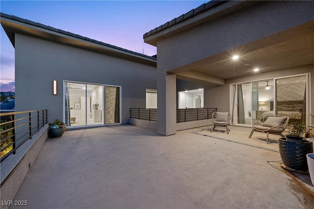 back of house with a balcony, a patio area, and stucco siding