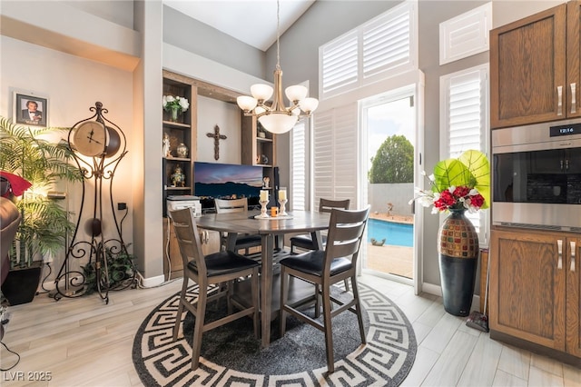 dining room with light wood-style floors, vaulted ceiling, and a notable chandelier