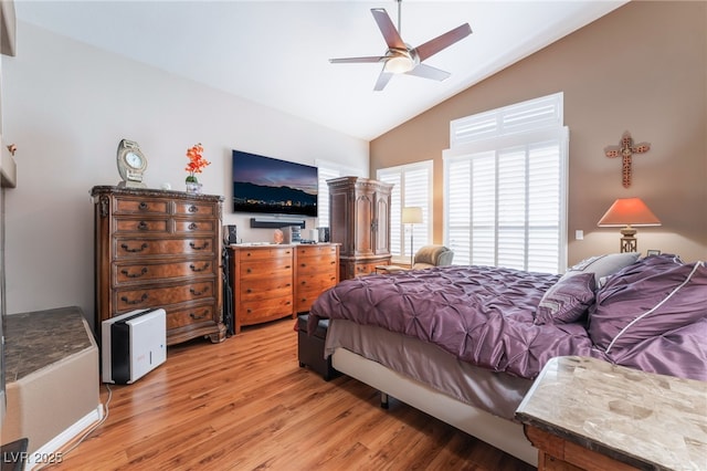 bedroom featuring light wood finished floors, a ceiling fan, and high vaulted ceiling