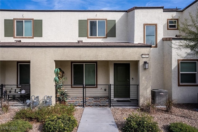 view of front facade with cooling unit, a porch, and stucco siding