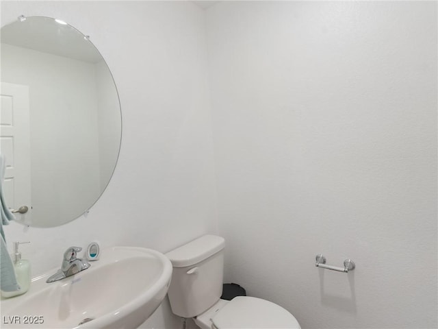 half bath featuring a sink and toilet