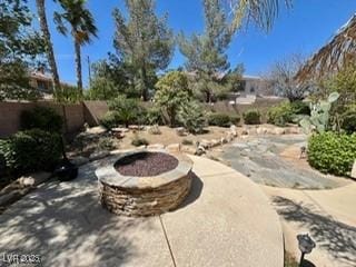 view of patio with an outdoor fire pit and fence