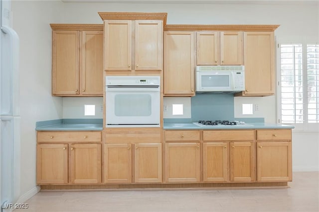 1100 Cypress Ridge Ln, Las Vegas, NV 89144 - kitchen with white appliances, light brown cabinets, light countertops, and baseboards
