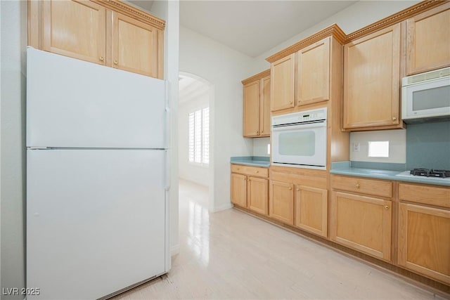1100 Cypress Ridge Ln, Las Vegas, NV 89144 - kitchen featuring white appliances, light brown cabinets, arched walkways, light countertops, and light wood finished floors