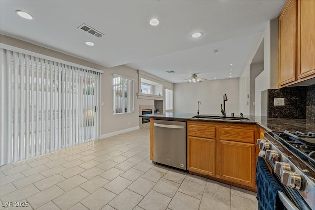 1287 Dove Tree Ct, Henderson, NV 89014 - kitchen featuring a peninsula, a ceiling fan, a sink, appliances with stainless steel finishes, and light tile patterned flooring