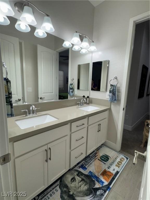 bathroom featuring a chandelier, double vanity, and a sink