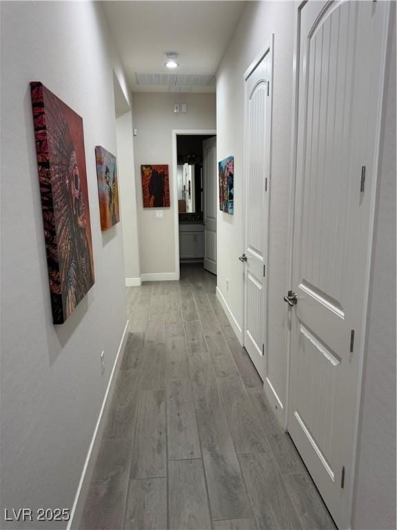 hallway featuring baseboards and wood finished floors