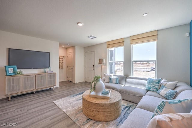 living area with wood finished floors, baseboards, and recessed lighting