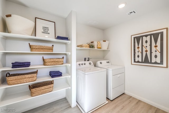 washroom with light wood finished floors, laundry area, visible vents, baseboards, and independent washer and dryer