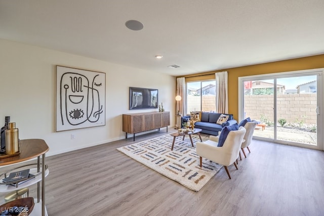 living room with visible vents, wood finished floors, baseboards, and recessed lighting