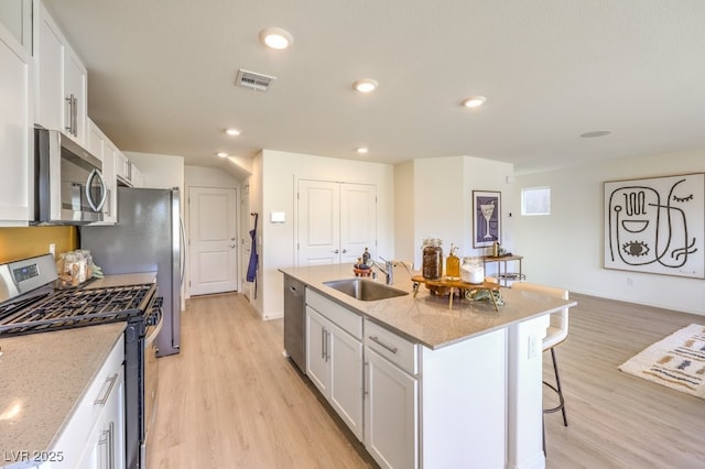 kitchen with a sink, light wood-style flooring, visible vents, and appliances with stainless steel finishes