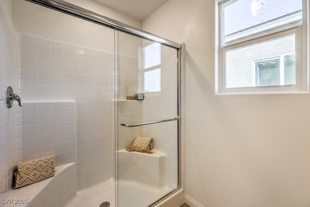 full bathroom with baseboards and a shower with door