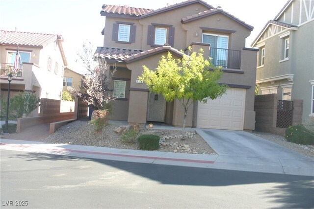 mediterranean / spanish home with driveway, stucco siding, a tiled roof, and a garage