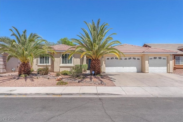 view of front of property with a tiled roof, stucco siding, driveway, and a garage