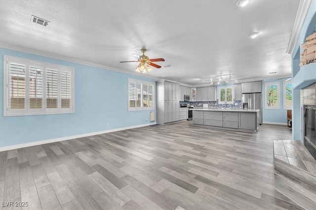 kitchen with visible vents, a tile fireplace, light countertops, appliances with stainless steel finishes, and gray cabinets