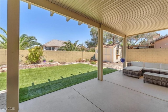 view of patio with a storage shed, an outbuilding, an outdoor hangout area, and a fenced backyard