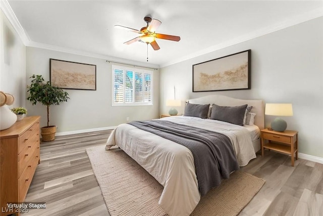 bedroom featuring baseboards, ceiling fan, light wood-style flooring, and crown molding