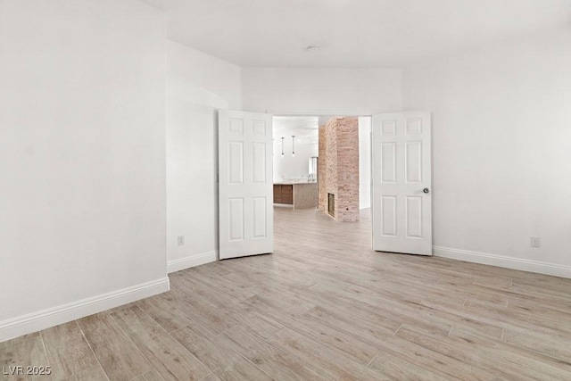 empty room with baseboards and light wood-style flooring