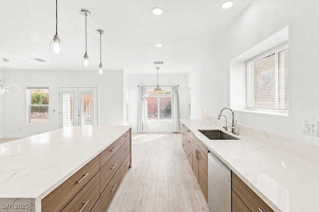 kitchen featuring a sink, a spacious island, dishwashing machine, and a healthy amount of sunlight
