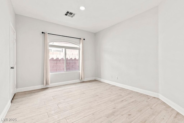 unfurnished room with baseboards, light wood-style floors, and visible vents
