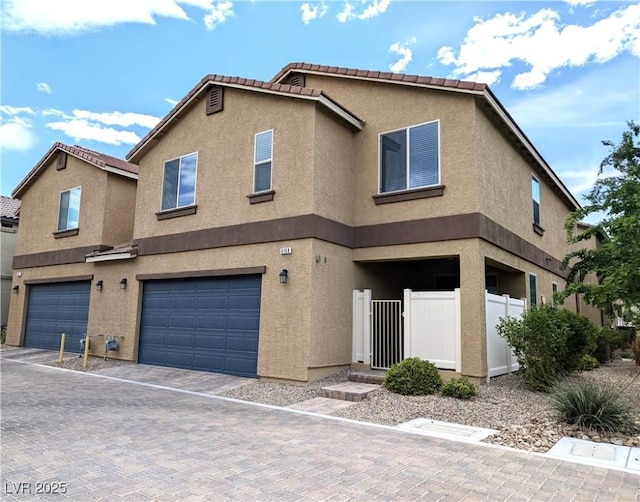 6168 Scarlet Leaf St, Las Vegas, NV 89148 - view of property with stucco siding, an attached garage, a tile roof, and decorative driveway
