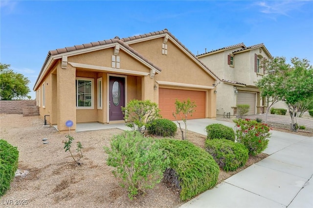view of front of home featuring concrete driveway, stucco siding, and a garage