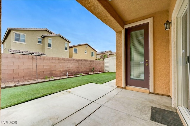 view of patio with a fenced backyard, a storage unit, and an outbuilding