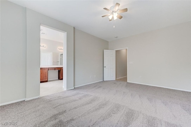 interior space with light carpet, baseboards, and a ceiling fan