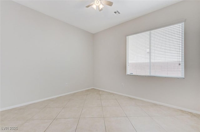 spare room with light tile patterned flooring, visible vents, baseboards, and a ceiling fan
