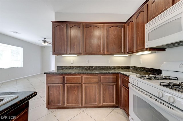 kitchen with white appliances, dark stone counters, visible vents, ceiling fan, and light tile patterned floors