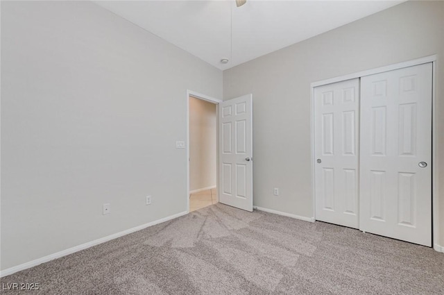 unfurnished bedroom featuring baseboards, carpet flooring, a closet, and ceiling fan
