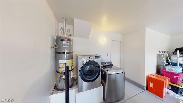 laundry area with baseboards, laundry area, independent washer and dryer, and water heater