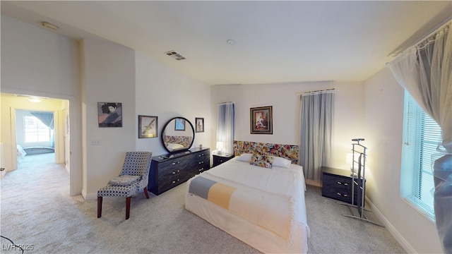 carpeted bedroom with lofted ceiling, baseboards, and visible vents