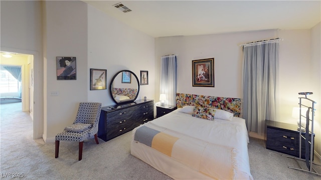 bedroom with baseboards, carpet flooring, visible vents, and high vaulted ceiling