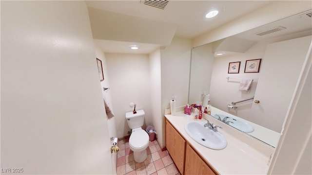 half bath with toilet, tile patterned flooring, vanity, and visible vents
