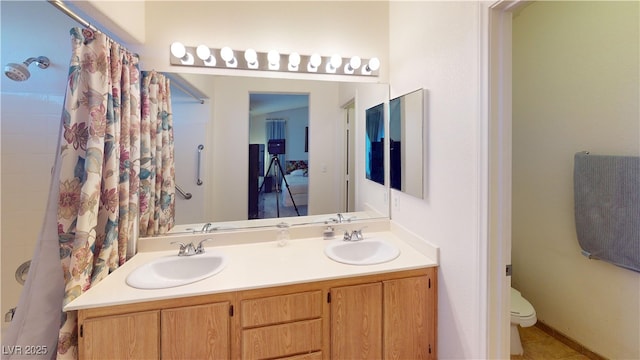 bathroom with double vanity, toilet, a shower with shower curtain, and a sink