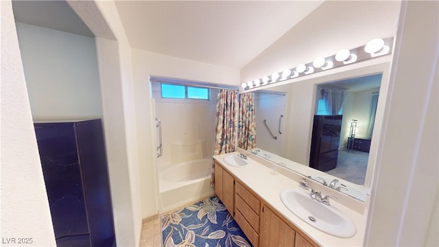 full bathroom featuring lofted ceiling, double vanity, and a sink