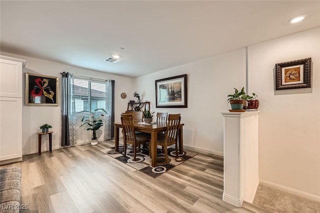 dining room featuring light wood finished floors, baseboards, visible vents, and recessed lighting