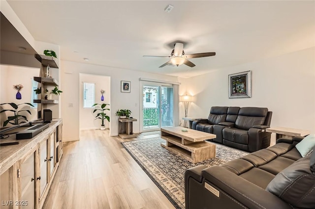 living room featuring plenty of natural light, light wood-style flooring, and a ceiling fan