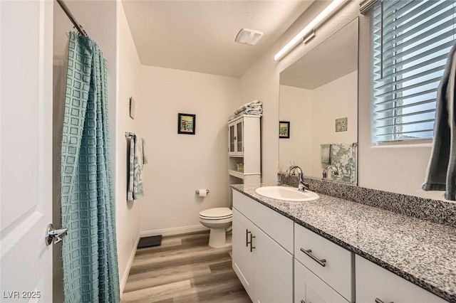 full bath with toilet, wood finished floors, a shower with curtain, baseboards, and vanity
