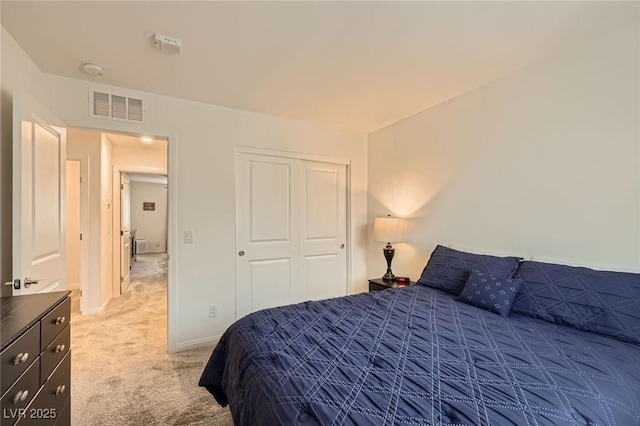 bedroom with a closet, light carpet, baseboards, and visible vents