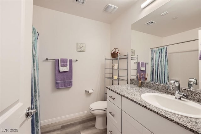 bathroom with toilet, wood finished floors, visible vents, baseboards, and vanity