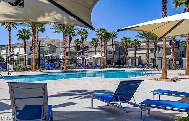 community pool with fence, a residential view, and a patio area
