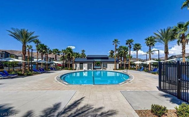 community pool with fence, a residential view, and a patio